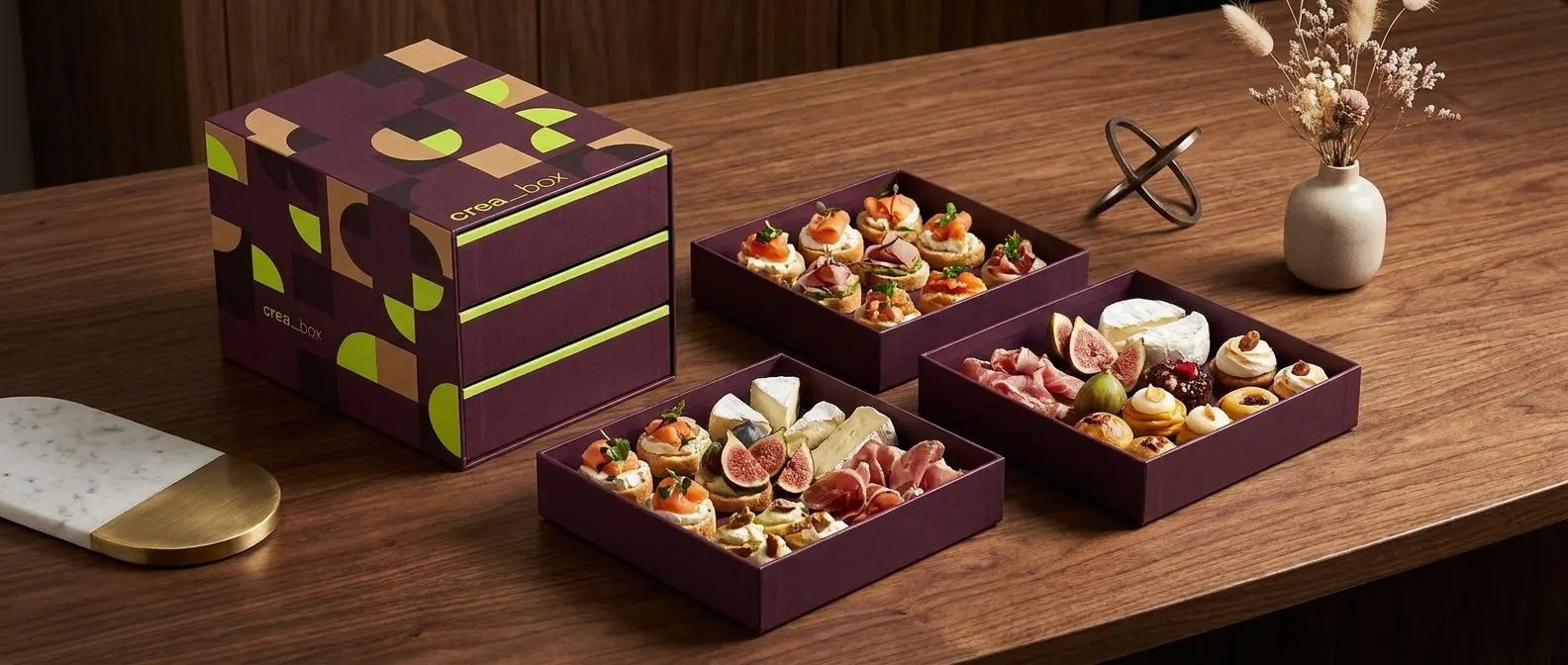 Box crea_box con bandejas de referencias gourmet sobre una mesa de madera